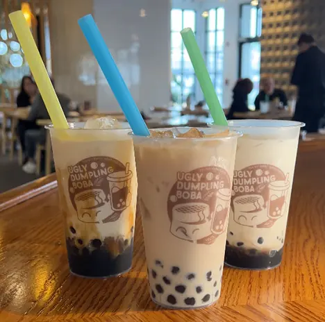 Three Ugly Dumpling boba milk teas with yellow, blue and green straws